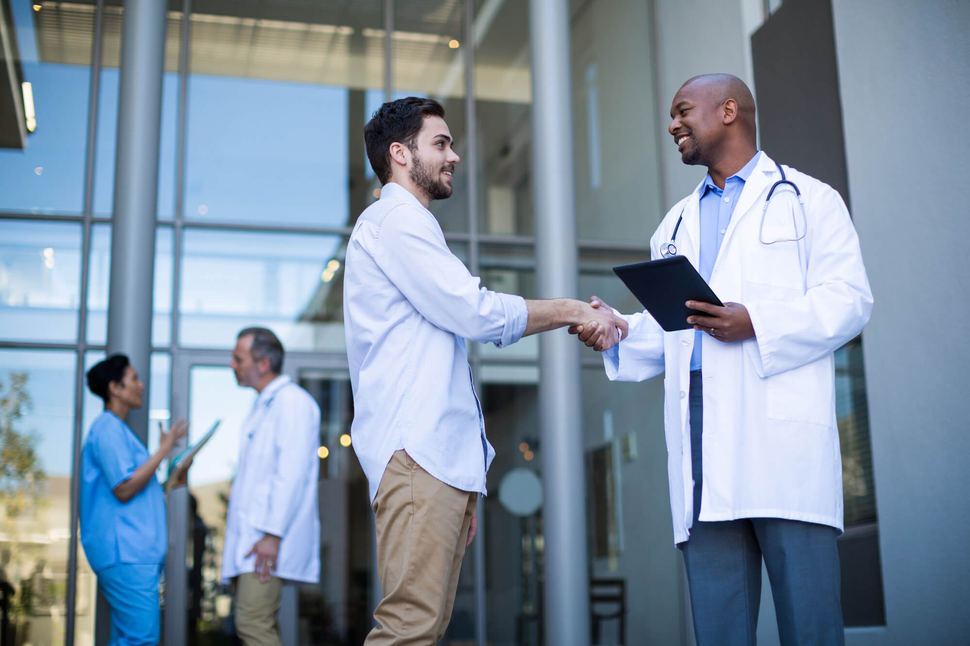 Médico conversando com um rapaz a respeito da saúde do homem com objetivo de convencê-lo a ir em uma consulta.