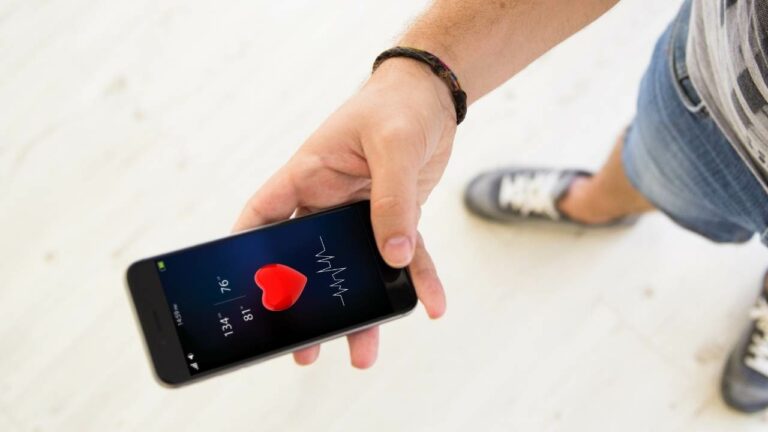 Homem segurando celular com aplicativo de saúde aberto.