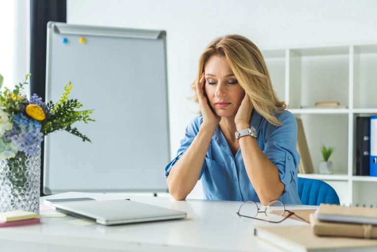 Mulher no trabalho sofrendo sintomas de stress