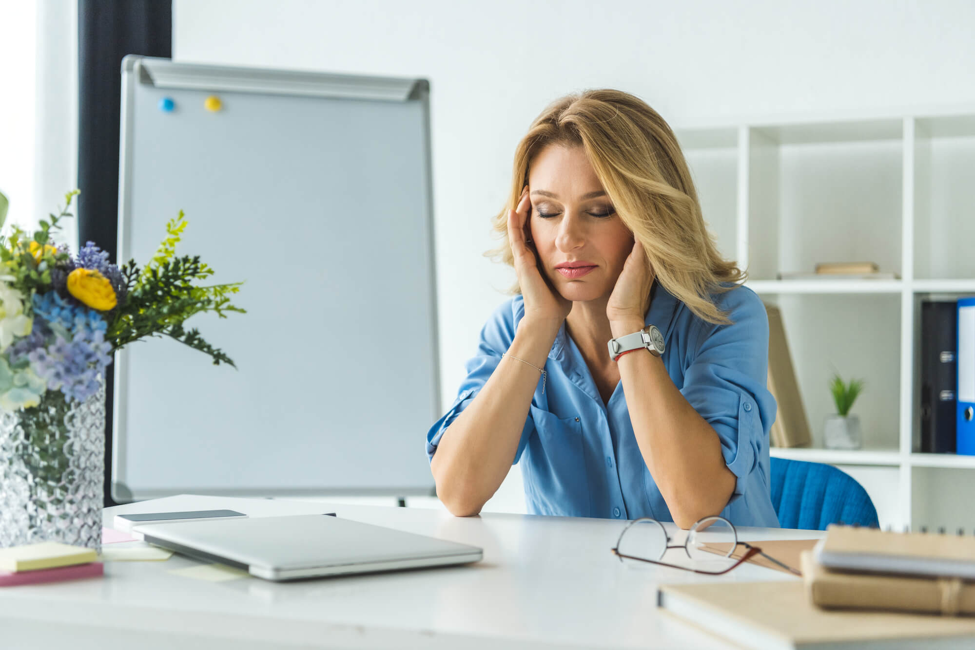 Mulher no trabalho sofrendo sintomas de stress