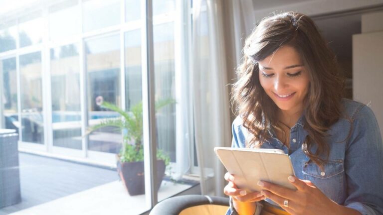 Mulher usando tablet para agendar consulta online.