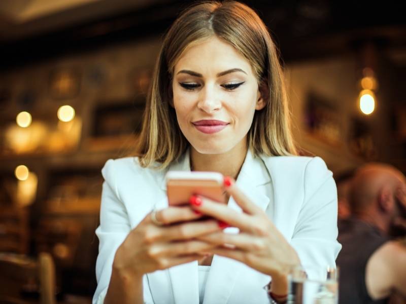 Mulher jovem usando o celular.