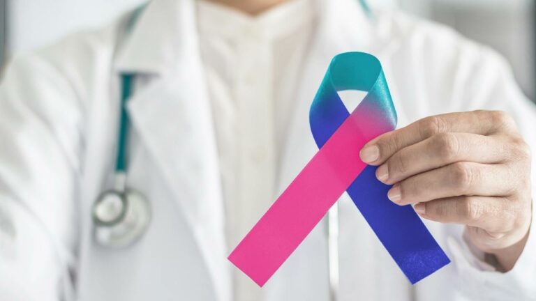 Médico segurando laço símbolo do combate ao câncer.