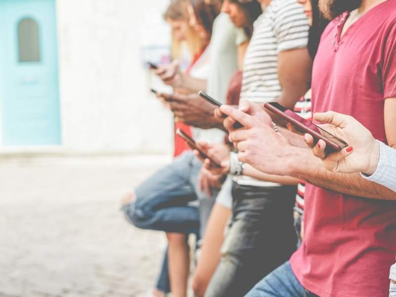 Grupo de pessoas usando o celular.
