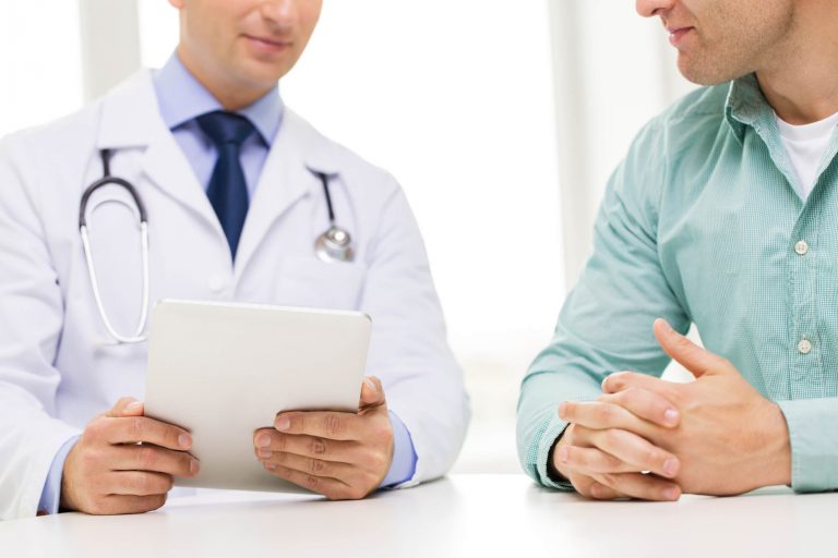 Médico conversando com homem sobre exames periódicos a serem realizados.