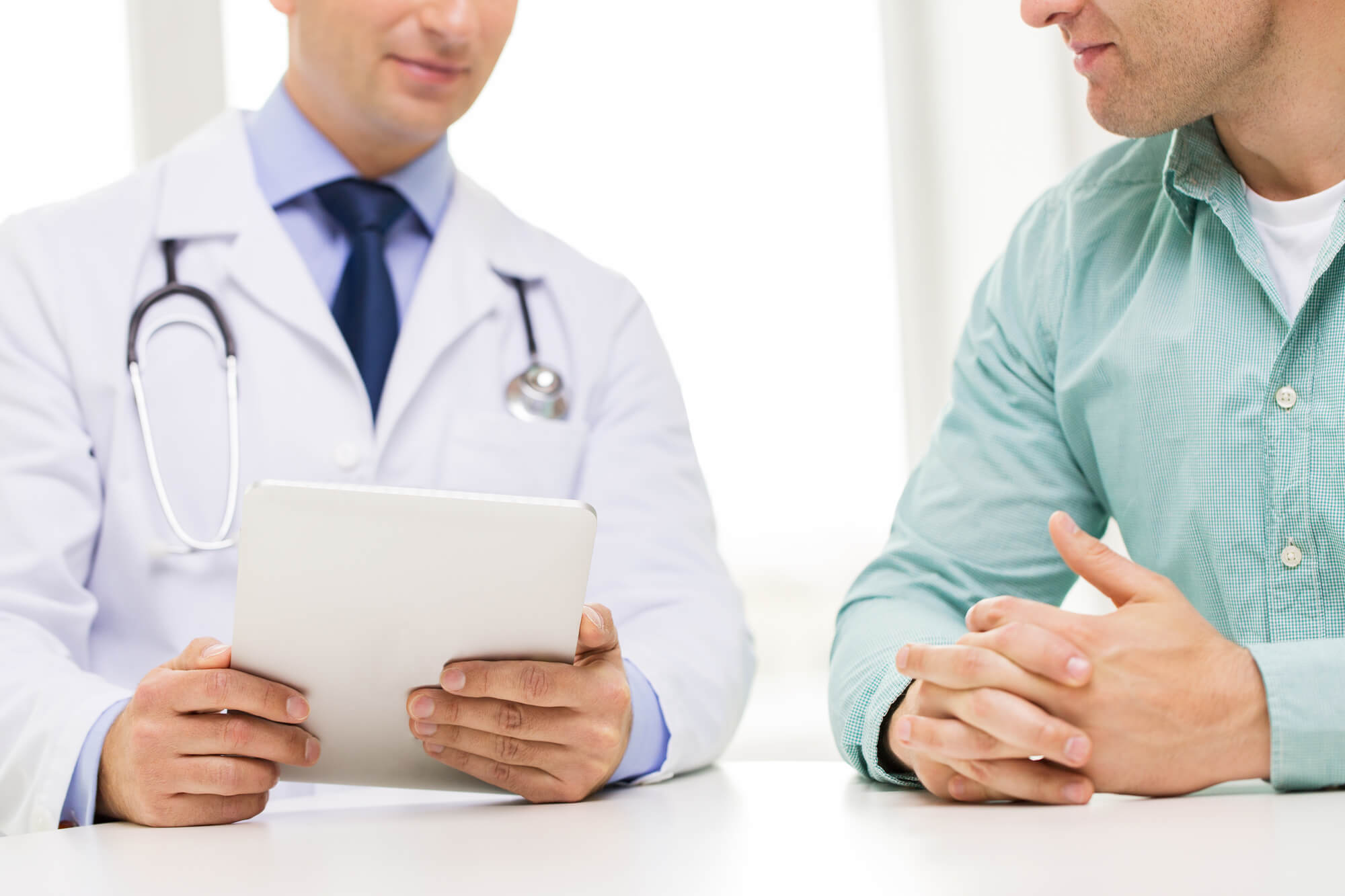 Médico conversando com homem sobre exames periódicos a serem realizados.