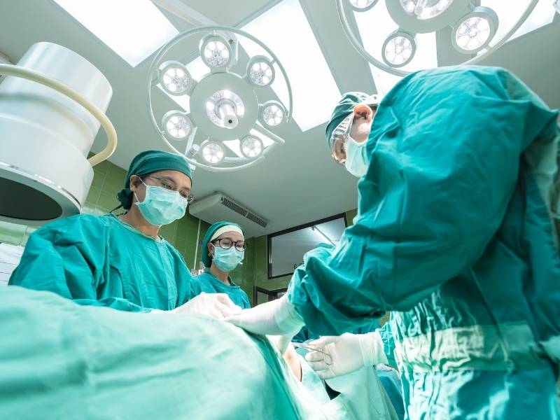 Médicos na sala de cirurgia realizando procedimento estético.