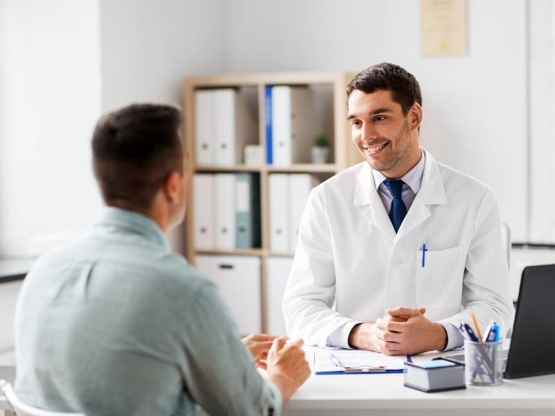 Paciente e médico conversando no consultório urológico.