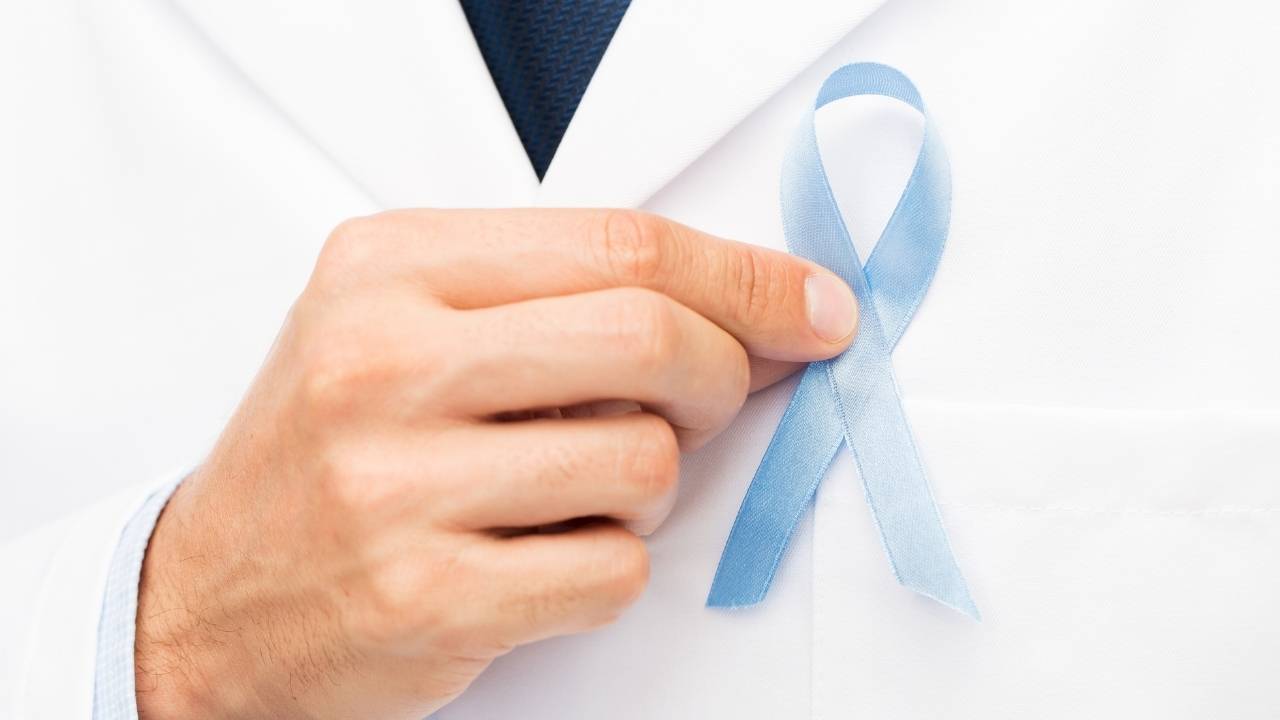 Médico homem segurando laço azul da campanha novembro azul.