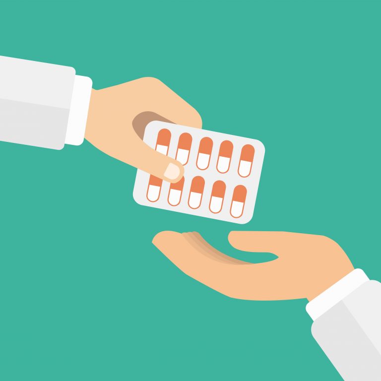 Na imagem, uma mão aparece entregando uma cartela de medicamentos para outra mão.