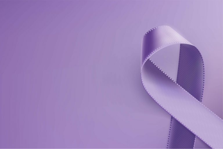 Na imagem, um laço roxo aparece em um fundo da mesma cor.