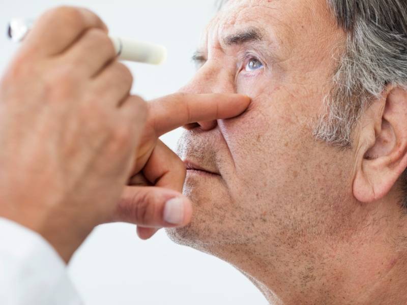 Oftalmologista realizando testes médicos em paciente.