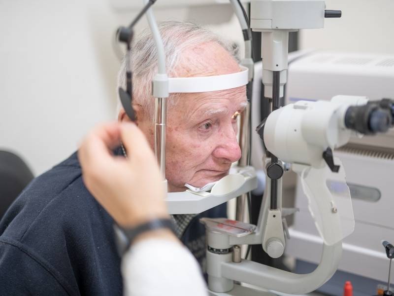 Homem idoso fazendo exames de rotina com oftalmologista.
