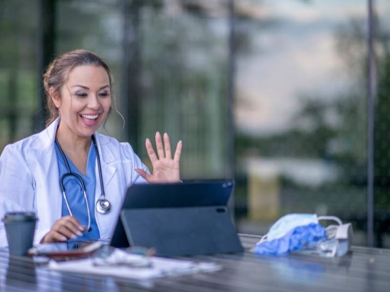 Médica atendendo paciente através da internet.