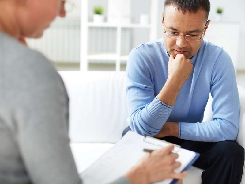Homem recebendo atendimento de profissional de psicologia. 