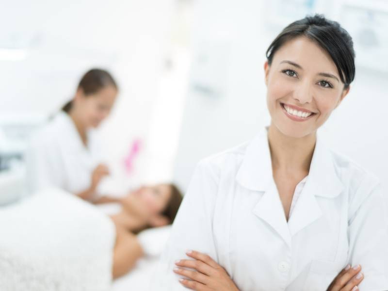 Mulher dermatologista com os braços cruzados.