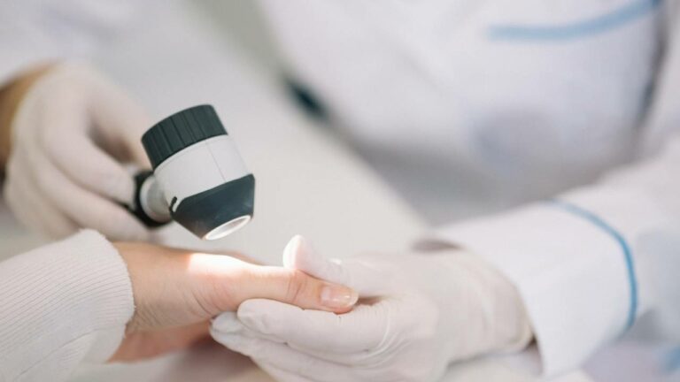 Dermatologista examinando pele de paciente.