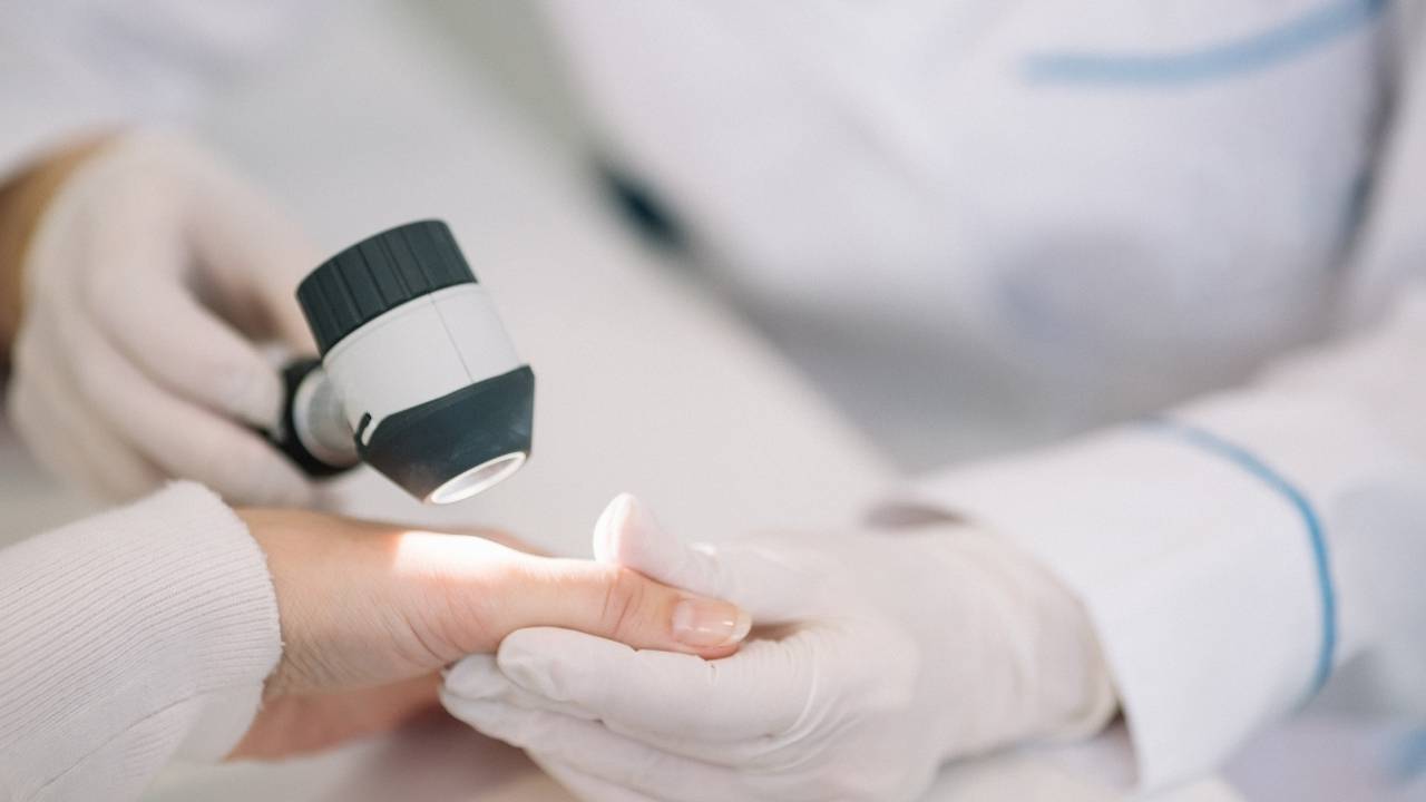 Dermatologista examinando pele de paciente.