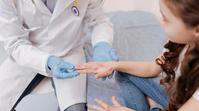 Médico dermatologista examinando a mão de criança.