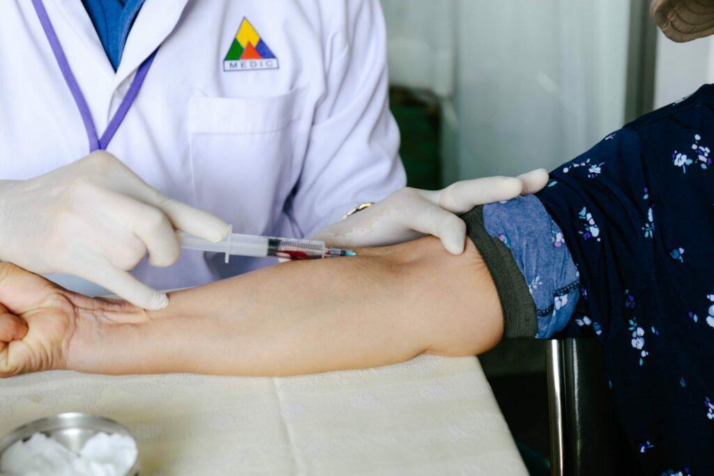 Médico realizando exame de sangue em paciente homem.