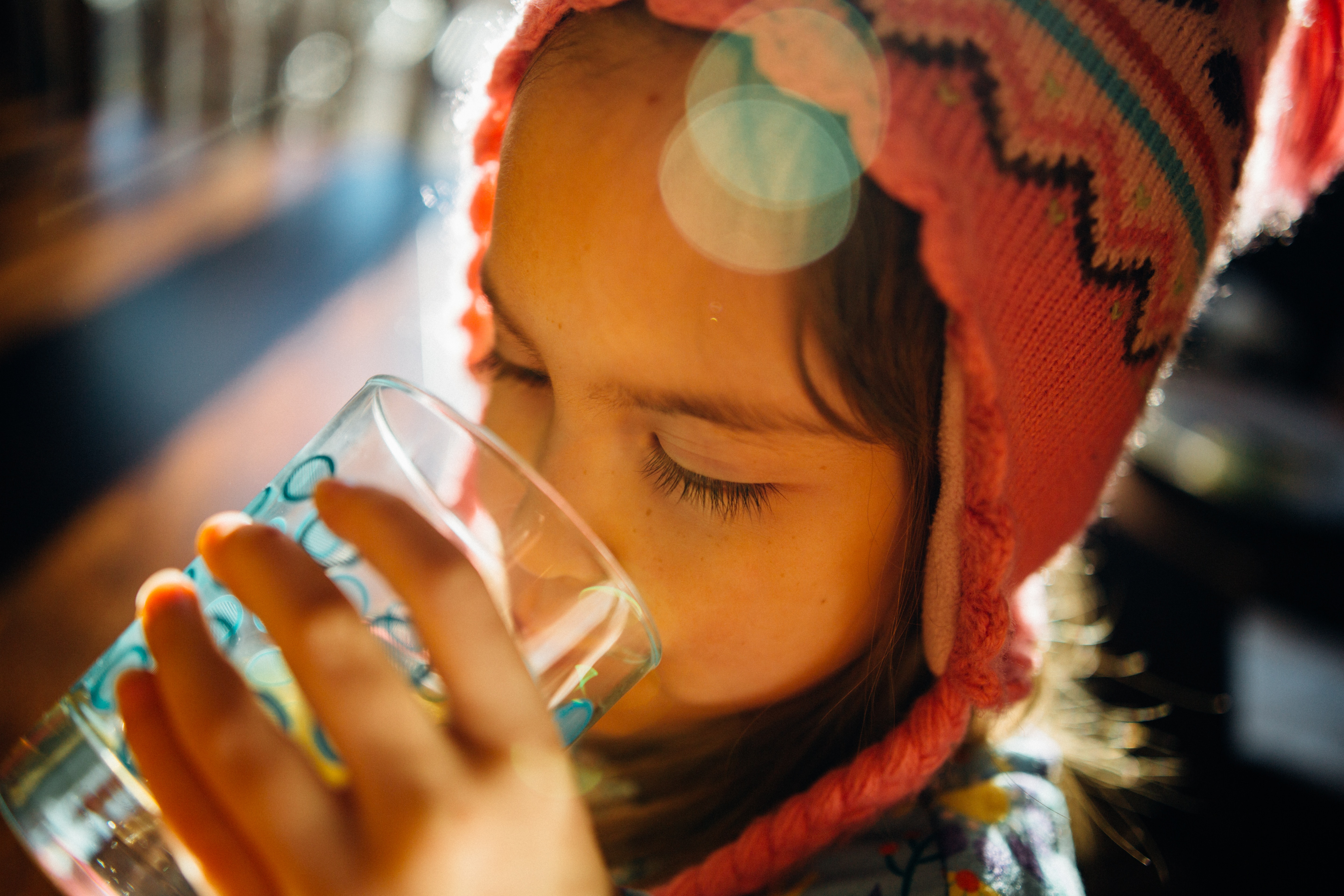 Criança menina bebendo agua.