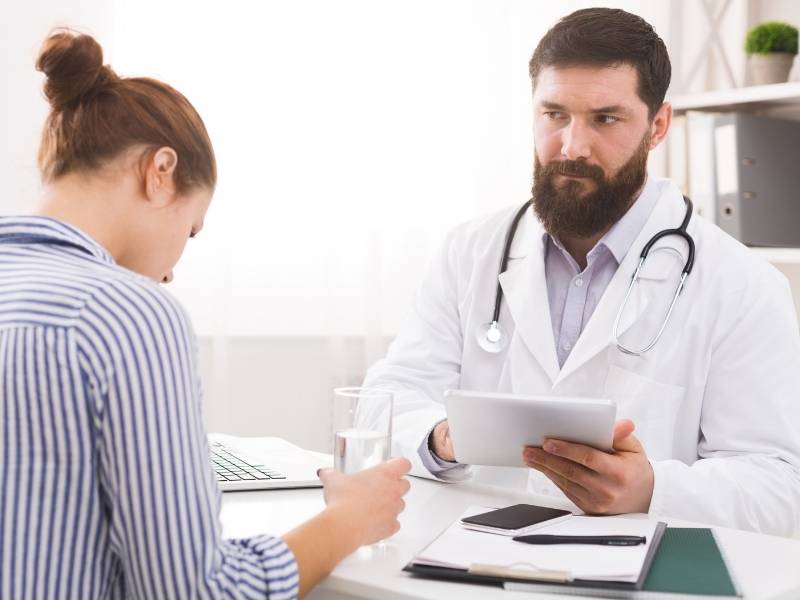 Médico especialista em câncer de mama conversando com paciente.