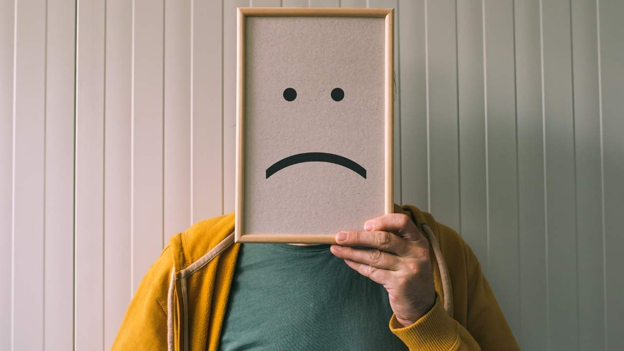 Imagem ilustrativa de pessoa com quadro a frente do rosto simbolizando tristeza e depressão.
