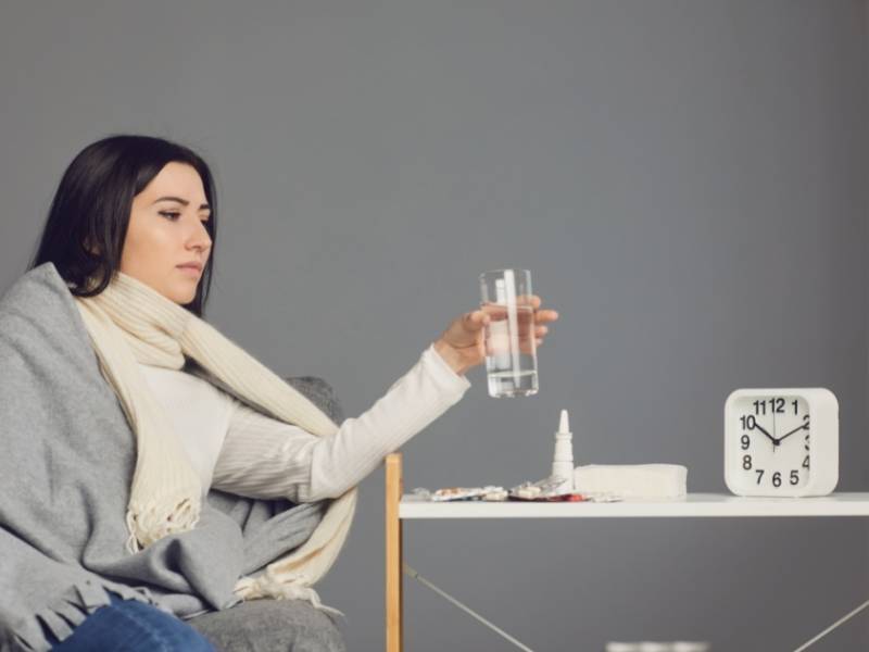 Mulher sentada e bebendo agua.