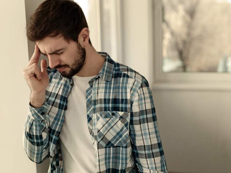 Homem jovem com dores físicas em razão dos efeitos da depressão.