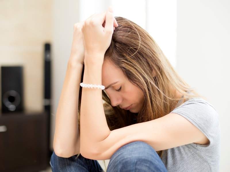 Mulher jovem sentada triste.