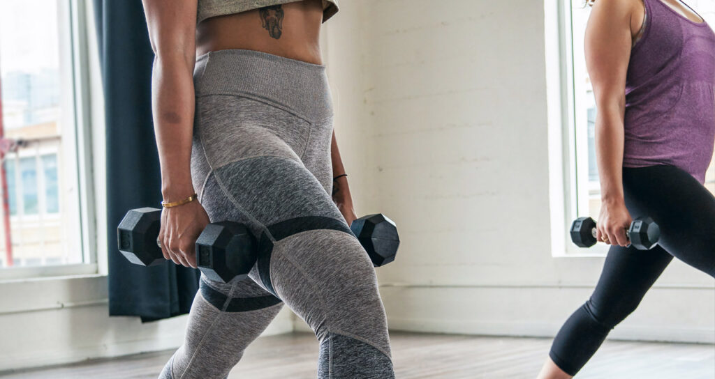 duas mulheres fazendo exercícios físicos com peso para melhorar a saúde mental