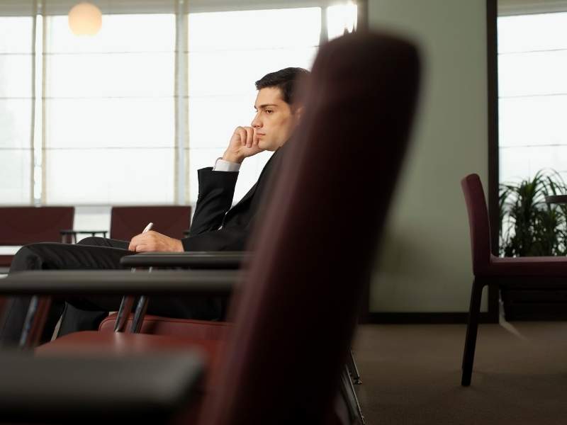 Homem jovem sentado observando.