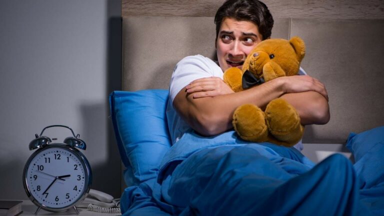 Homem na cama com feição de preocupado.
