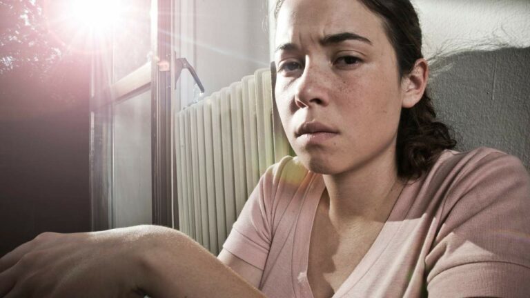 Mulher sentada com feição triste.