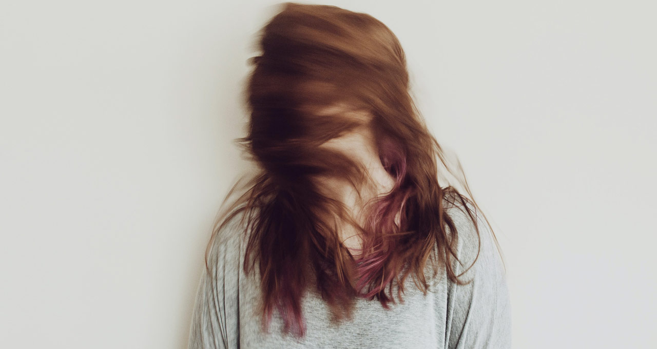 mulher ruiva mexendo seus cabelos em sinal de ter tremores constantes