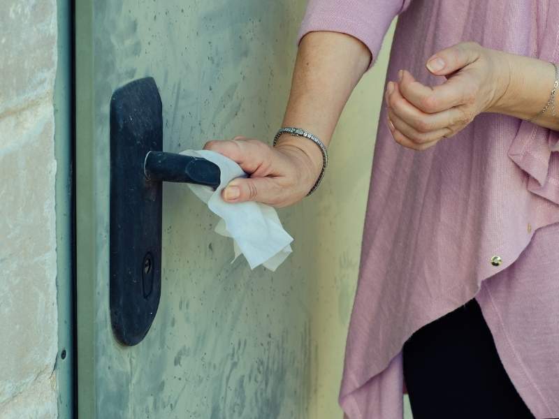 Mulher jovem pegando na maçaneta da porta.