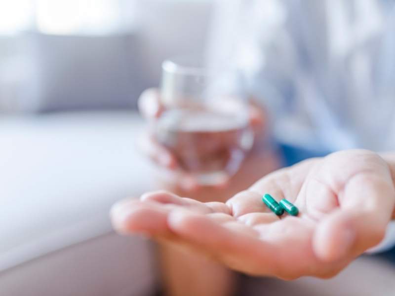 Mulher segunda remédios antidepressivos na mão.