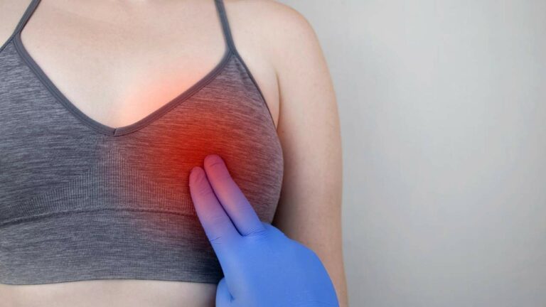 Médico avaliando carocinhos na mama de mulher.