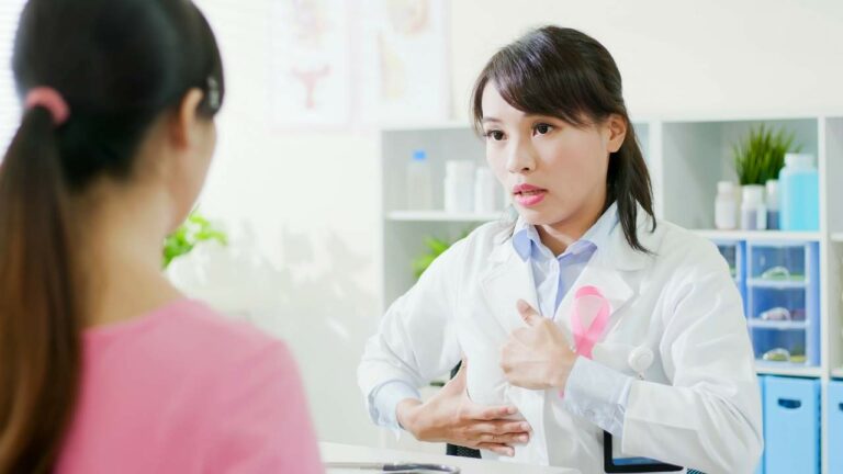 Médica ensinando a identificar o caroço do câncer de mama.