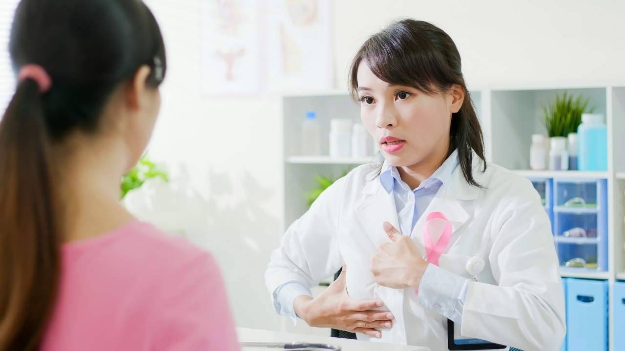 Médica ensinando a identificar o caroço do câncer de mama.