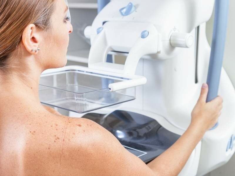 Mulher realizando exame de mamografia.