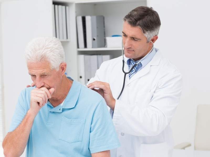 Paciente com tosse sendo examinado por médico.