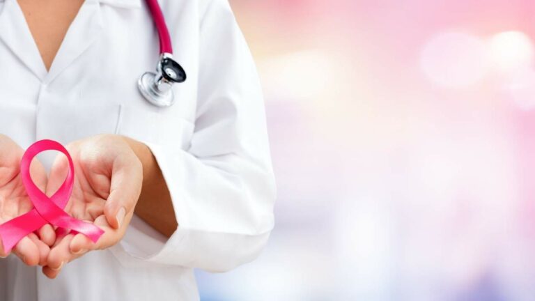 Médica segurando laço símbolo do outubro rosa.
