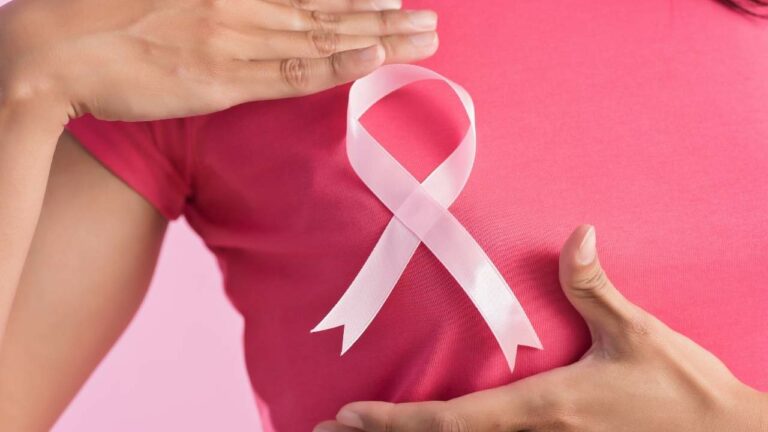 Mulher com laço rosa símbolo do outubro rosa.