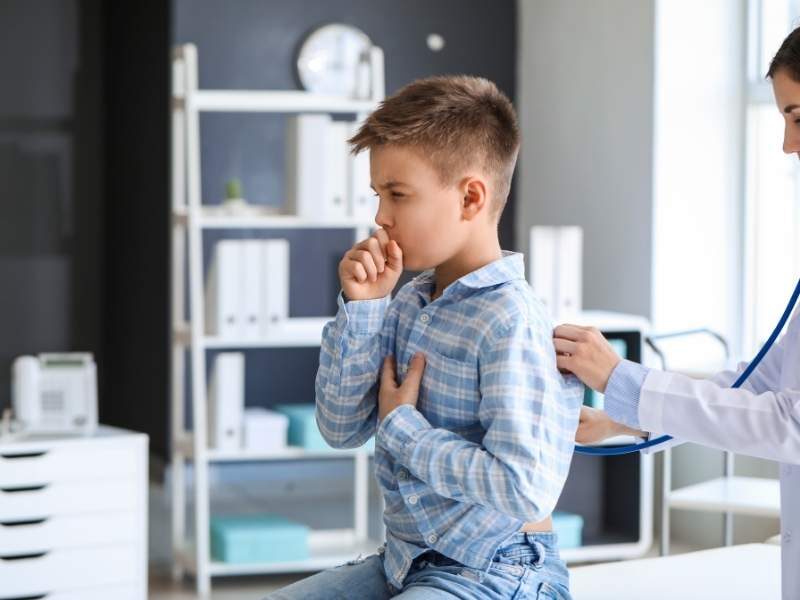 Médica analisando tosse de criança para indicar tratamento.