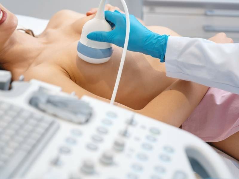 Mulher realizando exame de ultrassom para detectar a presença de nódulos.