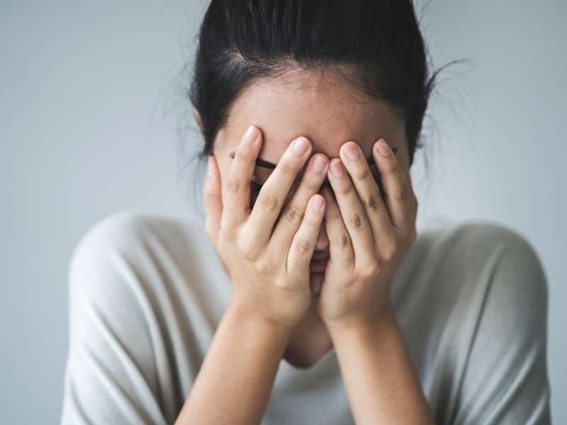 Mulher com ansiedade colocando as mãos no rosto.