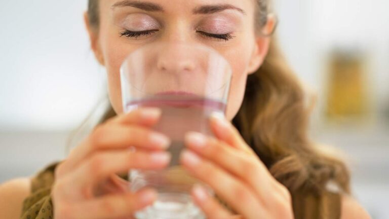 Mulher bebendo agua com sede excessiva.