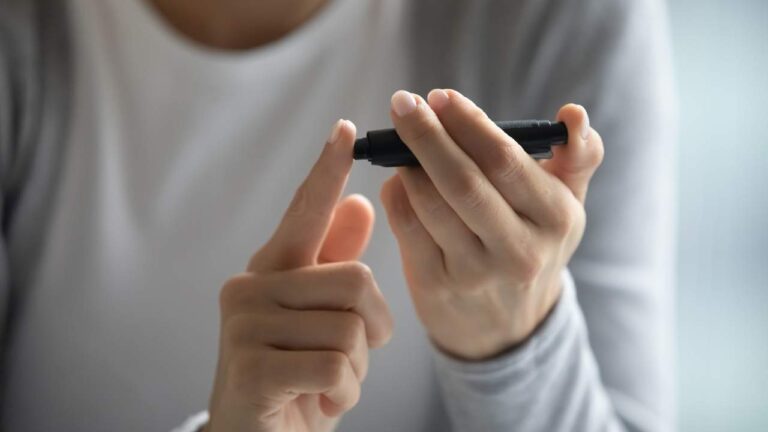 Mulher jovem aferindo níveis de glicemia para ver diabetes.