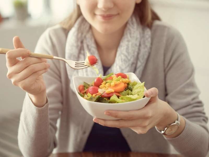 Mulher comendo alimentos saudáveis para prevenir infarto.